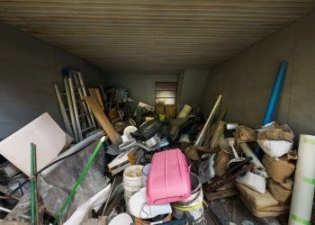 An overflowing container filled with a large assortment of junk, featuring a mix of debris and unwanted items